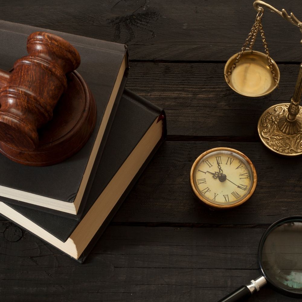Gavel, law books and scales on a wooden desk